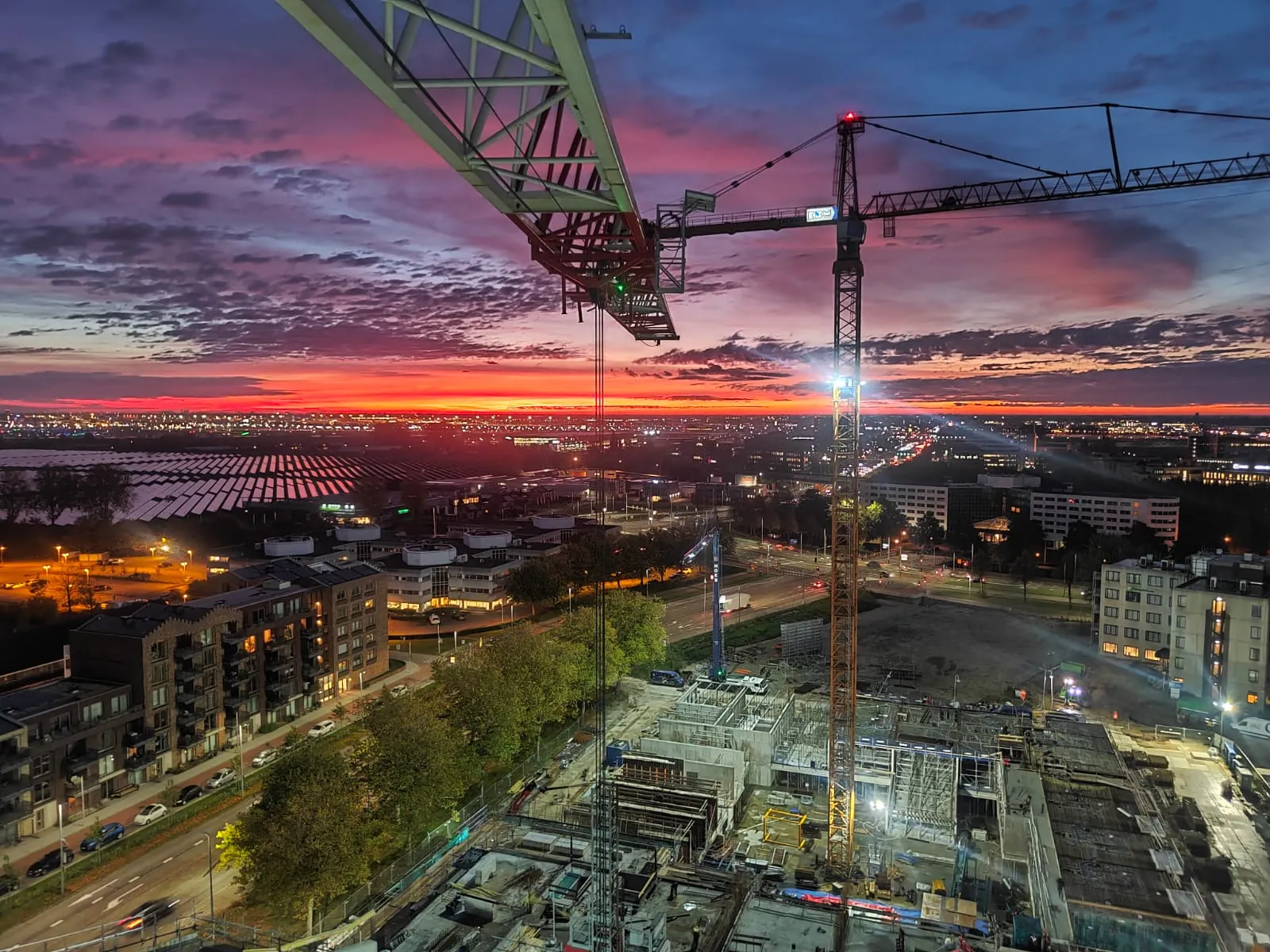 Torenkranen boven de bouwplaats bij avondrood