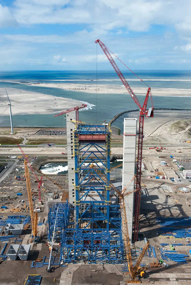 Torenkranen bij de bouw van een grote installatie aan de kust